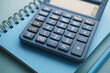 © Towfiqu Barbhuiya  - Close up of blue calculator and notepad on color background