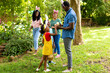 Happy african american siblings wearing bunny ears with family in backyard on easter day