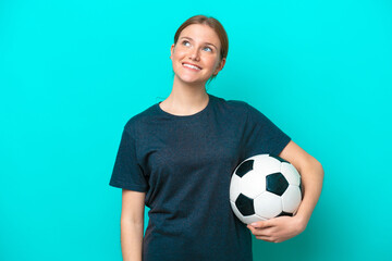 Wall Mural - Young football player woman isolated on blue background thinking an idea while looking up