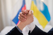 © Halfpoint - Representatives of Ukraine and Russia shaking hands, Ukraine peace agreement concept.