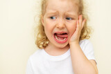 Fototapeta Desenie - The child has a toothache. Children's caries in the initial stage.