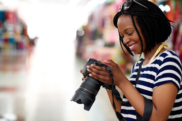 Aufkleber - Ive got some great pics so far. A young female tourist looking through her photographs while standing in a grocery store.