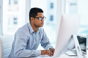 Wall Mural - the most technical mind in the company. shot of a young businessman using a computer in a modern off