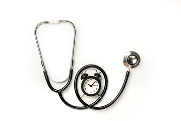 Stethoscope and alarm clock isolated on white background. The need to pass a medical examination on time.