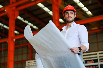 Portrait of architect and civil engineering builder holding layout plan on factory under construction site.