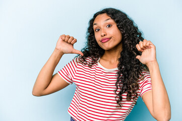 Wall Mural - Young hispanic woman isolated on blue background feels proud and self confident, example to follow.