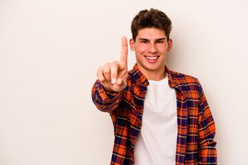 Young caucasian man isolated on white background showing number one with finger.