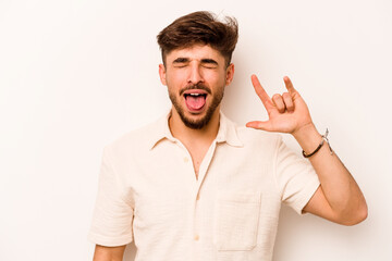 Wall Mural - Young hispanic man isolated on white background showing rock gesture with fingers