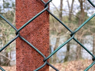 Wall Mural - the mesh of a wire mesh fence in front of a rusted metal post