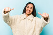 © Asier - Young hispanic woman isolated on blue background raising both thumbs up, smiling and confident.