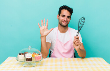 Wall Mural - hispanic handsome man smiling and looking friendly, showing number five. home made cakes cocnept