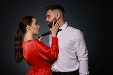 Wall Mural - Handsome bearded man with sexy lady on dark background