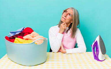 senior  gray hair woman thinking, feeling doubtful and confused iron and clothes concept