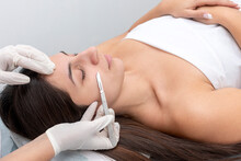 Young Woman In A Beauty Center Performing A Beauty Treatment For The Skin Of The Face With The Dermaplaning Technique