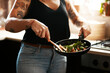 © Chanelle M/peopleimages.com - Stir fry, the healthy choice. Cropped shot of a woman preparing a meal at home.