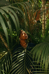 Wall Mural - A young black man dressed in blue standing outdoors amongst nature 