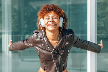 happy girl smiling with headphones on the street