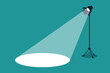 Silhouette of light lamp projector on a tripod with scattered rays. Projecting a beam of spotlight is glowing on down. Cinema background. Template for festive banner, flyer, poster with place for text