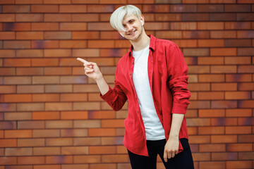 Wall Mural - Young happy man pointing at something. Man showing an offer.