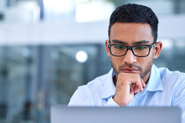 Aufkleber - I might need some time with this. Shot of a young businessman using his laptop at work.