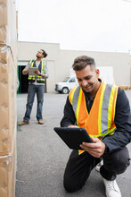 Cheerful Worker Using Digital Tablet On Warehouse Yard