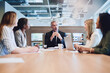 © AS/peopleimages.com - At the head of the table and the company. Low angle shot of a handsome mature businessman addressing his colleagues during a meeting in the boardroom.