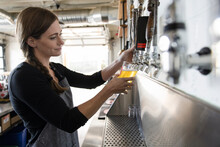 Close Up Of Bartender Pouring Beer Into Glass In Brewpub