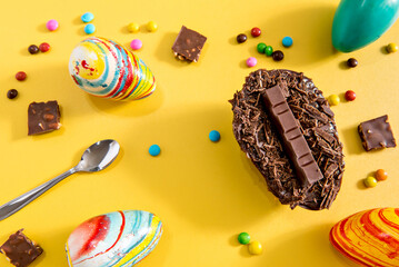 Wall Mural - Easter concept, Chocolate filled easter eggs on yellow background.