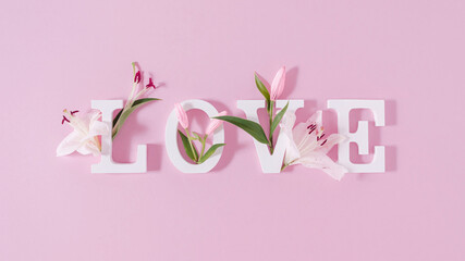 Wall Mural - Colorful love background. Floral Greeting card. Happy Women's Day. Spring flower flat lay holiday background with word Love. Nature Trendy Design. Happy Valentine's Day.