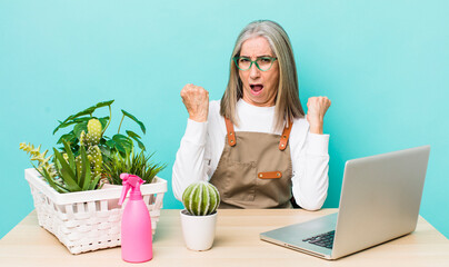 Wall Mural - senior gray hair woman shouting aggressively with an angry expression. gardener and plants concept