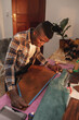 © Wavebreak Media - African american young craftsman measuring leather with tape measure while working in workshop