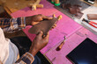 © Wavebreak Media - High angle midsection of african american young craftsman holding leather at table in workshop