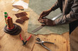 © Wavebreak Media - Midsection of african american young craftsman making outline on leather while working in workshop