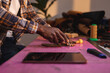 © Wavebreak Media - Midsection of african american young craftsperson cutting leather on mat in workshop