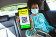 © Wavebreak Media - African american mid adult businesswoman showing phone with covid-19 vaccinated qr code in car