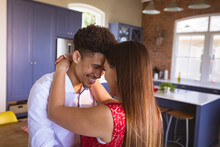 Happy Loving Young Biracial Couple Enjoying Romantic Dance In Kitchen At Home