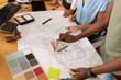 © Wavebreak Media - Female architects with blueprint discussing over color swatch in meeting at office