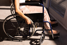 Mid Section Of African American Disabled Woman Sitting On Wheelchair Near The Window At Home