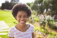 Portrait Of Cheerful African American Teenage Girl In Backyard On Sunny Day
