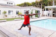 © Wavebreak Media - Senior african american man practicing warrior pose yoga on mat at poolside