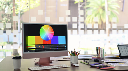 Wall Mural - design studio with computer, color swatches and wireframe sketches for mobile application on wooden 