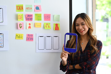 Wall Mural - professional web developer standing in creative office and smiling to camera.