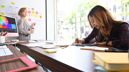 Wall Mural - female creative designer planning application and developing template layout, framework for mobile p