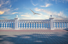 White Decorative Fence With Columns On The Seashore And Seagull In Sky