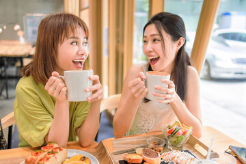 Canvas Print - Happy young women drinking coffee in cafe shop