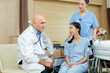 © eakgrungenerd - doctor treatment patient woman sitting on wheelchair in ward. take care encourage patient. healthcare concept.