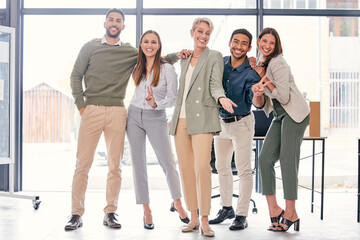 Wall Mural - We work hard and have fun too. Full length shot of a diverse group of businesspeople standing together and feeling playful in the office.