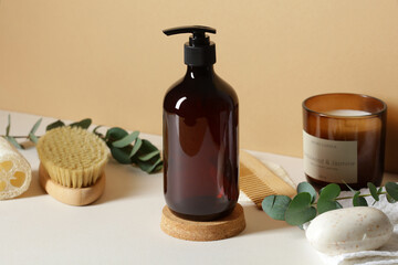 Wall Mural - amber glass shampoo bottle and bathroom accessories on table on beige background. spa natural organi