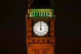 Fototapeta Big Ben - Big Ben of the Houses of Parliament London England UK at night striking midnight on new year's eve on Westminster Bridge which is a popular city landmark, stock photo with copy space
