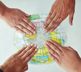 Poster - Reach out to the world. High angle shot of a group of unrecognisable people with their hands on a world globe.